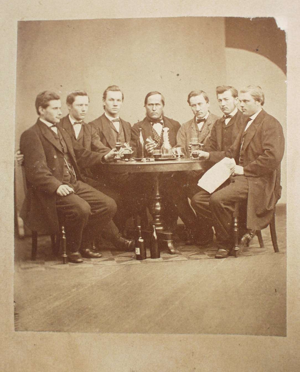 7 menn rundt et bord.