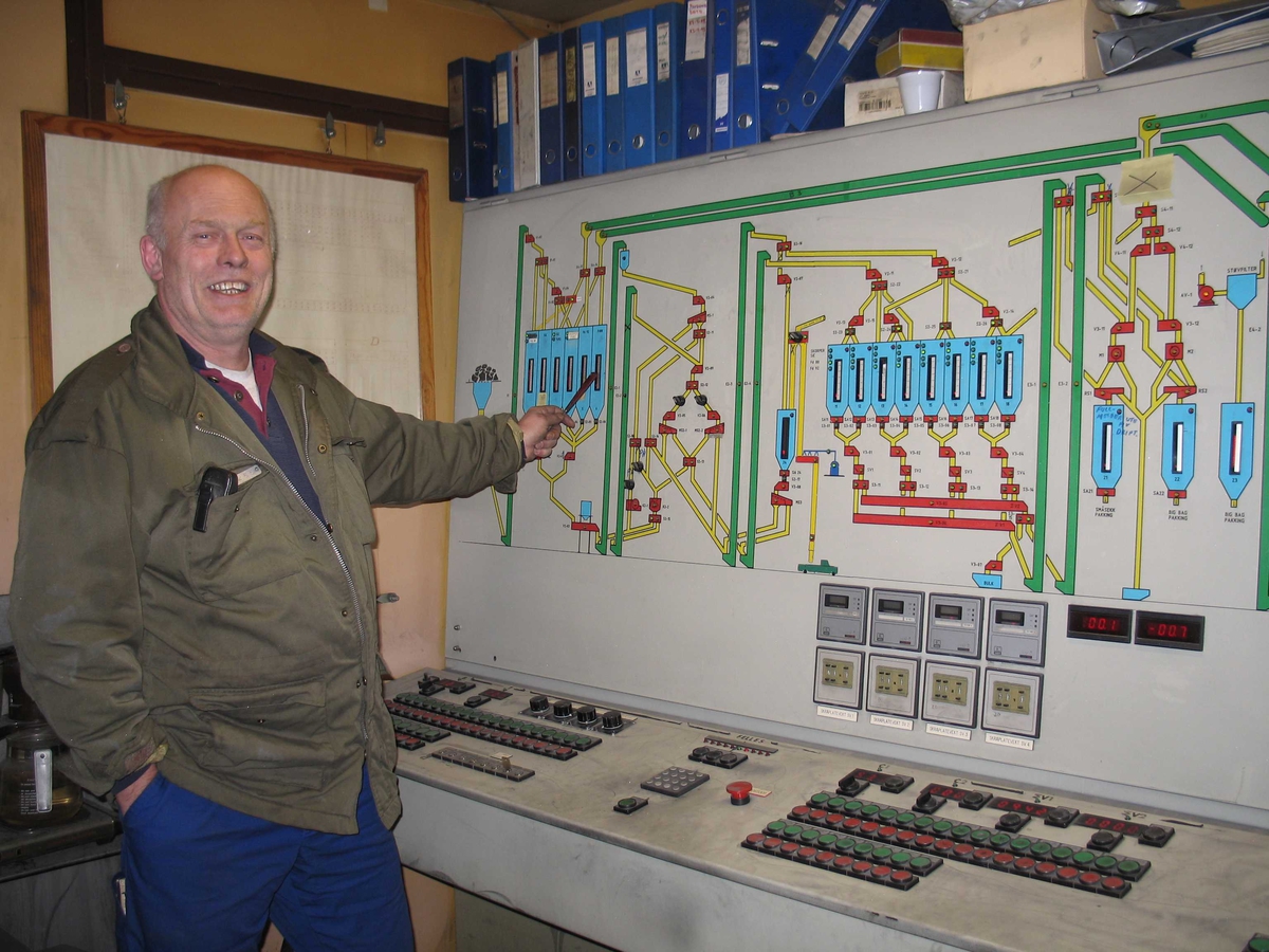 Arendal Smelteverk. Kranfører John Skaare ved tavla i kontrollrommet for råstoffhandtering. 