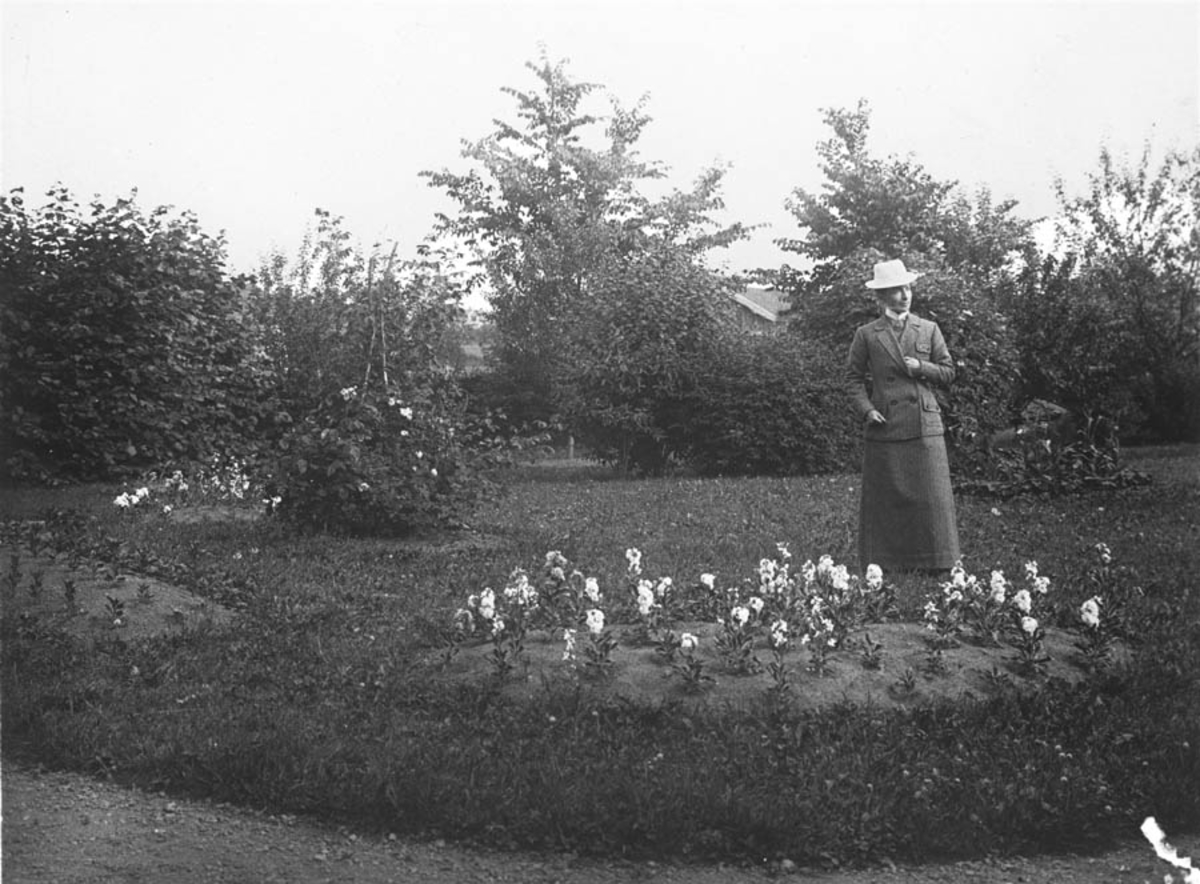 Olga Næristorp mellom blomsterbedene i haven på Vanaheim.
