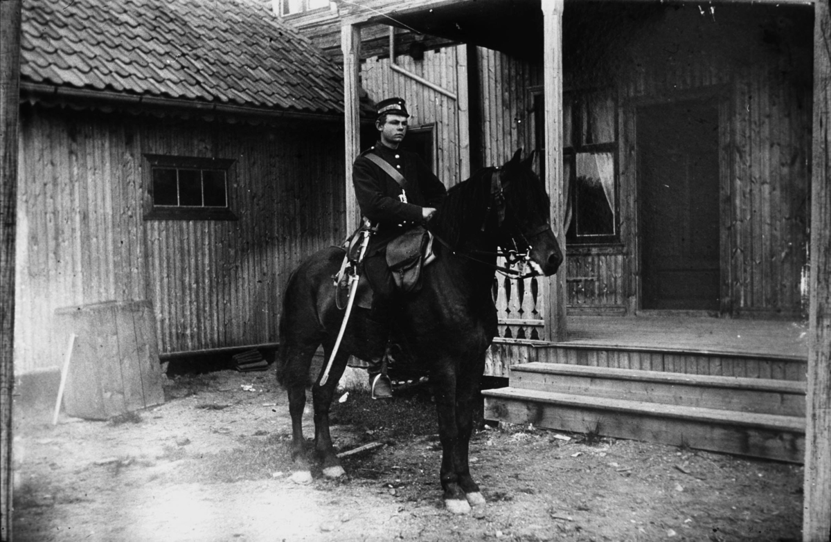Soldat til hest oppstilt inne i et gårdsrom.