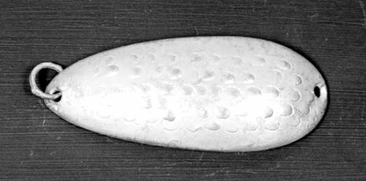 Skjesluk, brukt av Brynjulf Styve under fiske i Lågen. 
Sluken er sølvblank med skjellmønster. 
Sluken har hull i hver ende, med en ring i det ene. 
