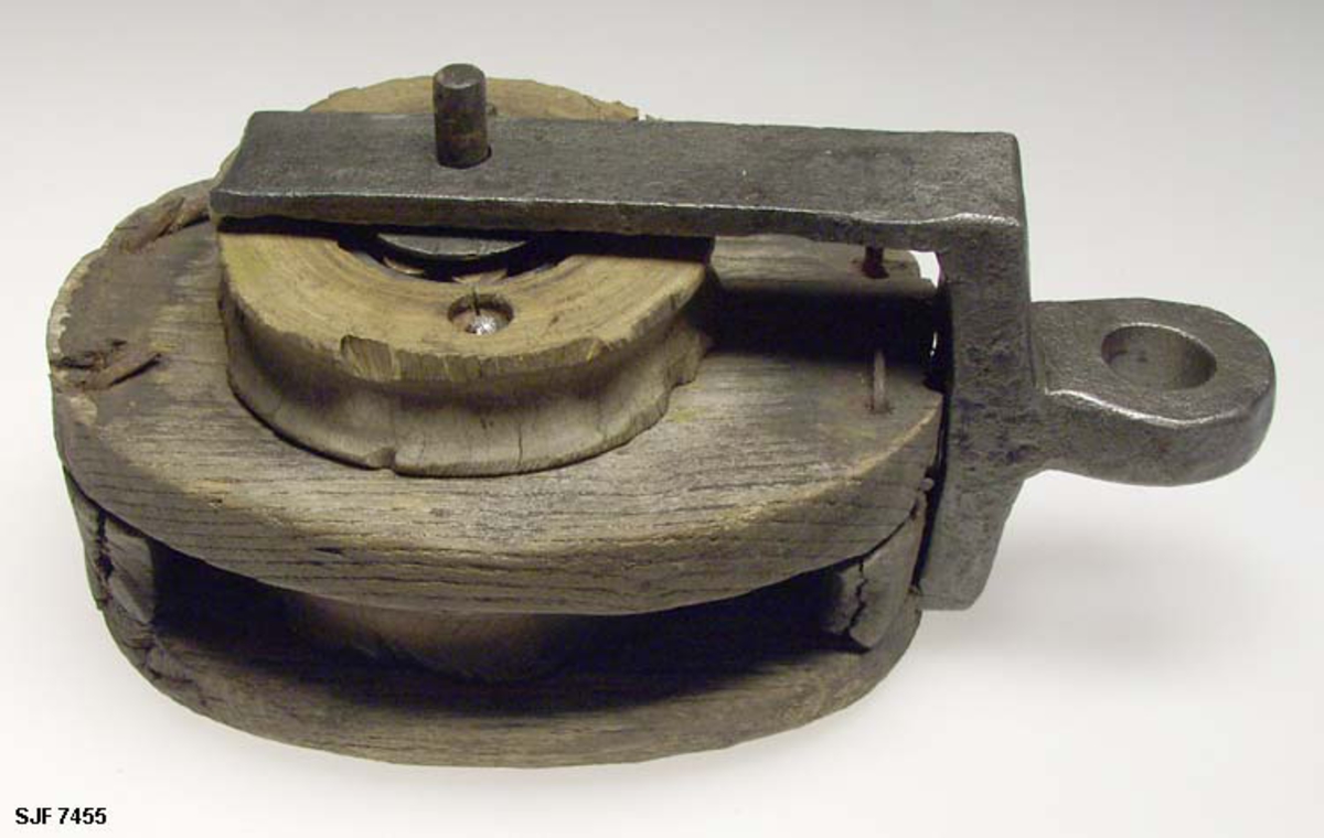 Form: Oval
Brukt på Hvaler, trolig i et båthus eller sjøhus. Blokken er i sin helhet lagd av tre med hjemmesmidd ramme av jern. 