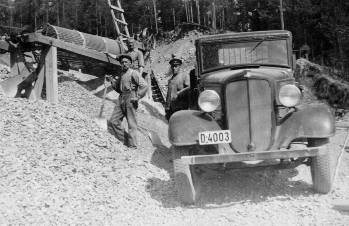 Lastebil, en 1934 modell Chevrolet med nummer D-4003. Laster pukk ved grustaket i Narudvegen, Byflatevegen, Brumunddal. Til høyre er Jørgen Nebba. Eier, ifølge Bilboken fra 1935 er Emil Holen, Veldre.