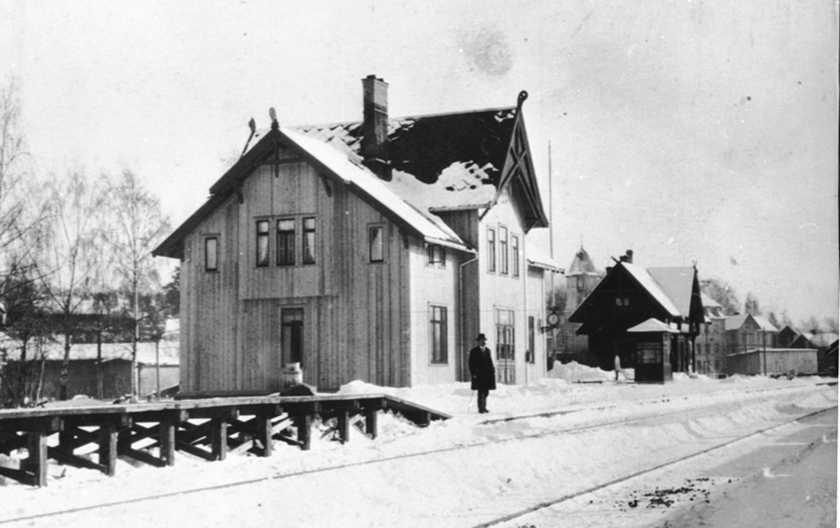 Brumunddal Jernbanestasjon, kiosk, lager, melkerampe, stasjonsbygning med ny panel, vinter, stasjonsmester fra 1922-1936 Edvard L. Nordhagen.