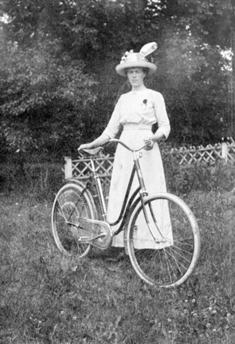 Thea Amundsdatter Berger (1889-1965) med sykkel. Kjole og hatt. Hun ble gift med Halvor Hovie.