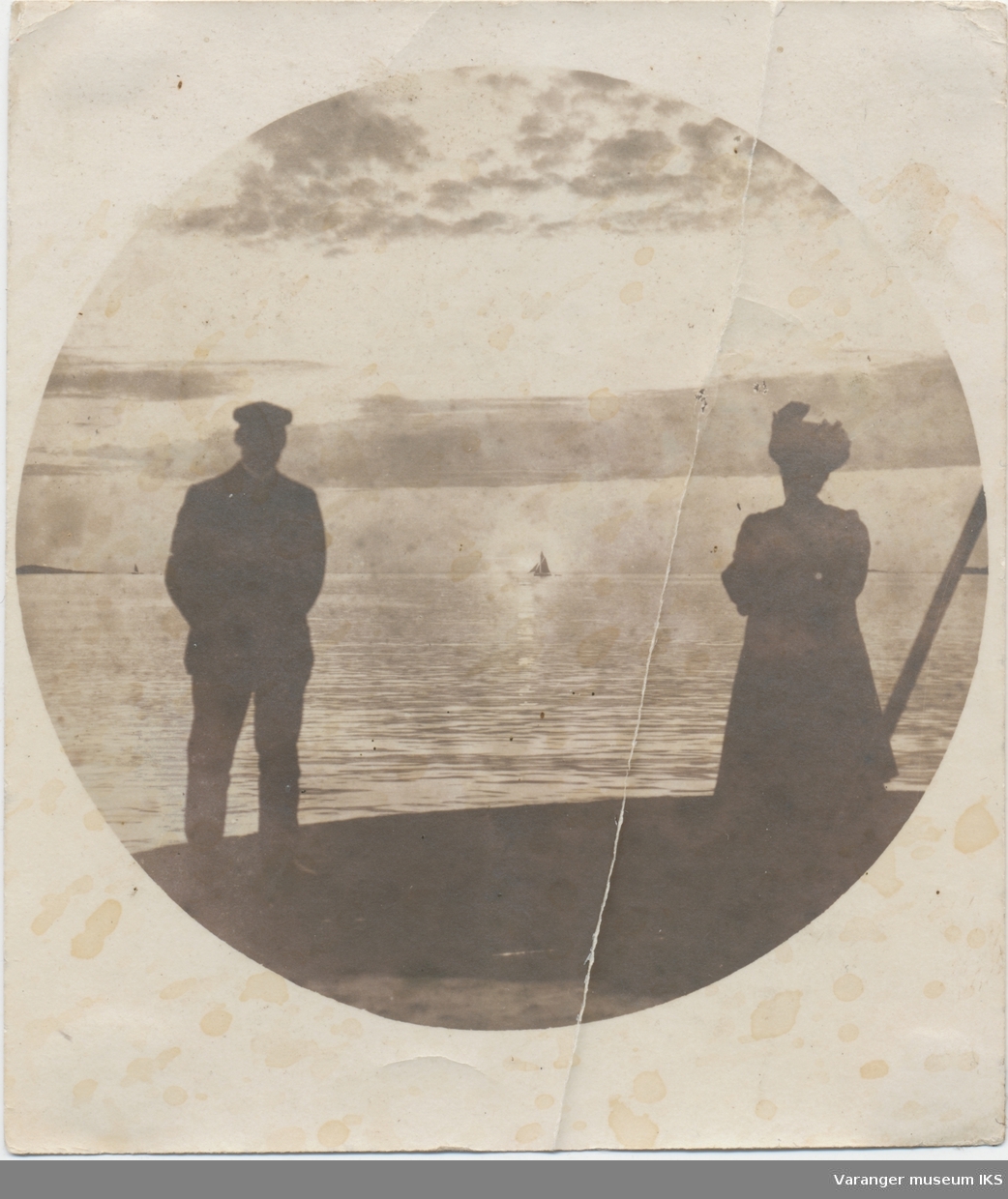 Siste midnattsol 27. juli 1900, mann og kvinne ytterst på østre moloarm i forgrunnen