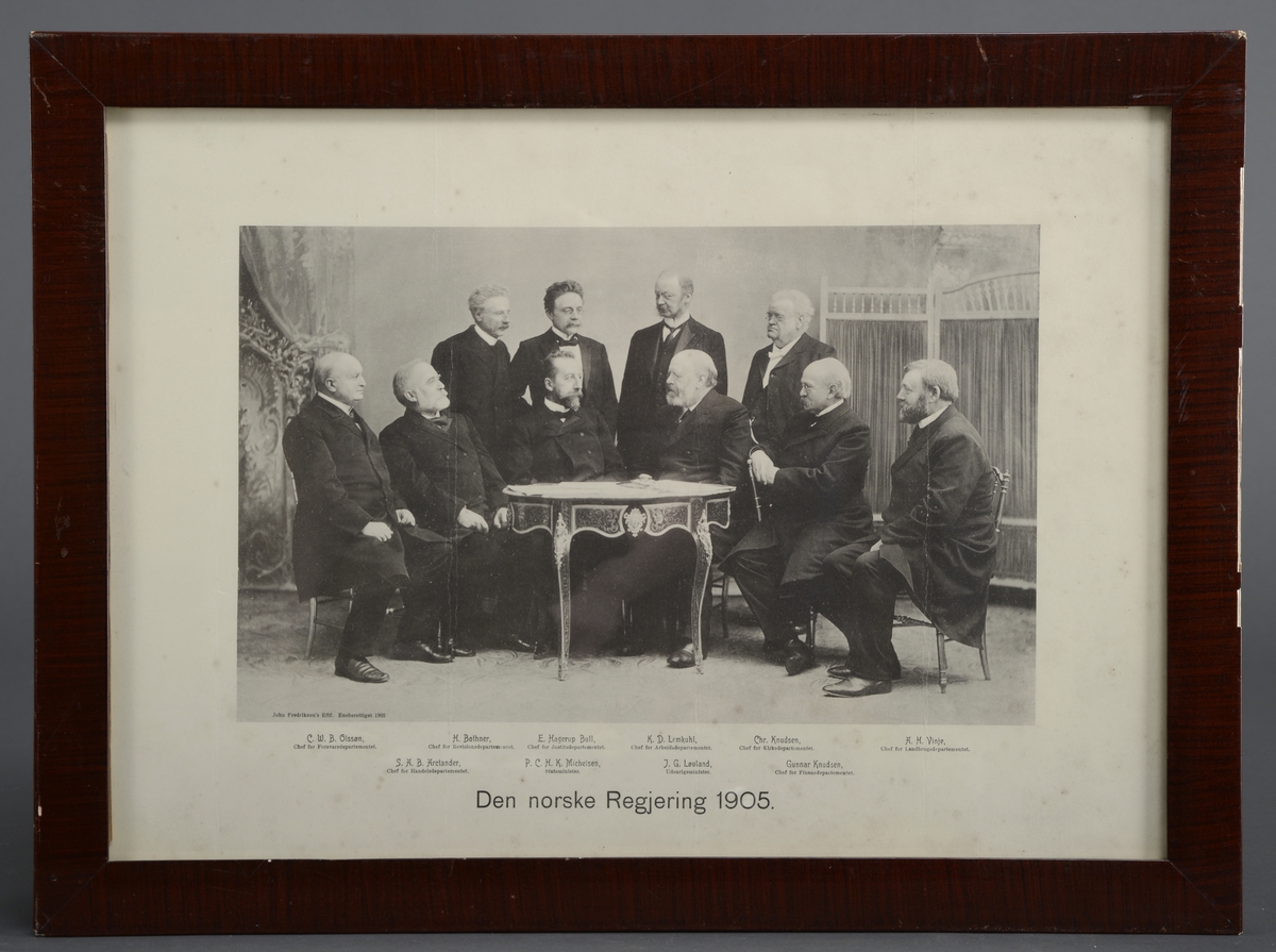 Den norske regjering i 1905 sittende og stående rundt et bord.
