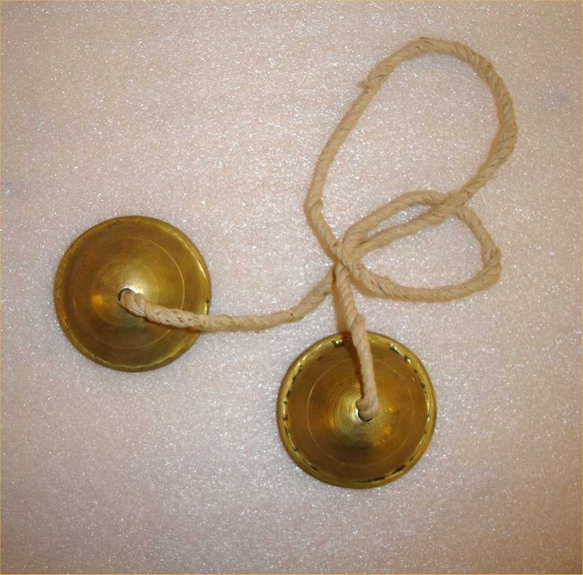 To små cymbaler, sammenlenket med et bånd. 

