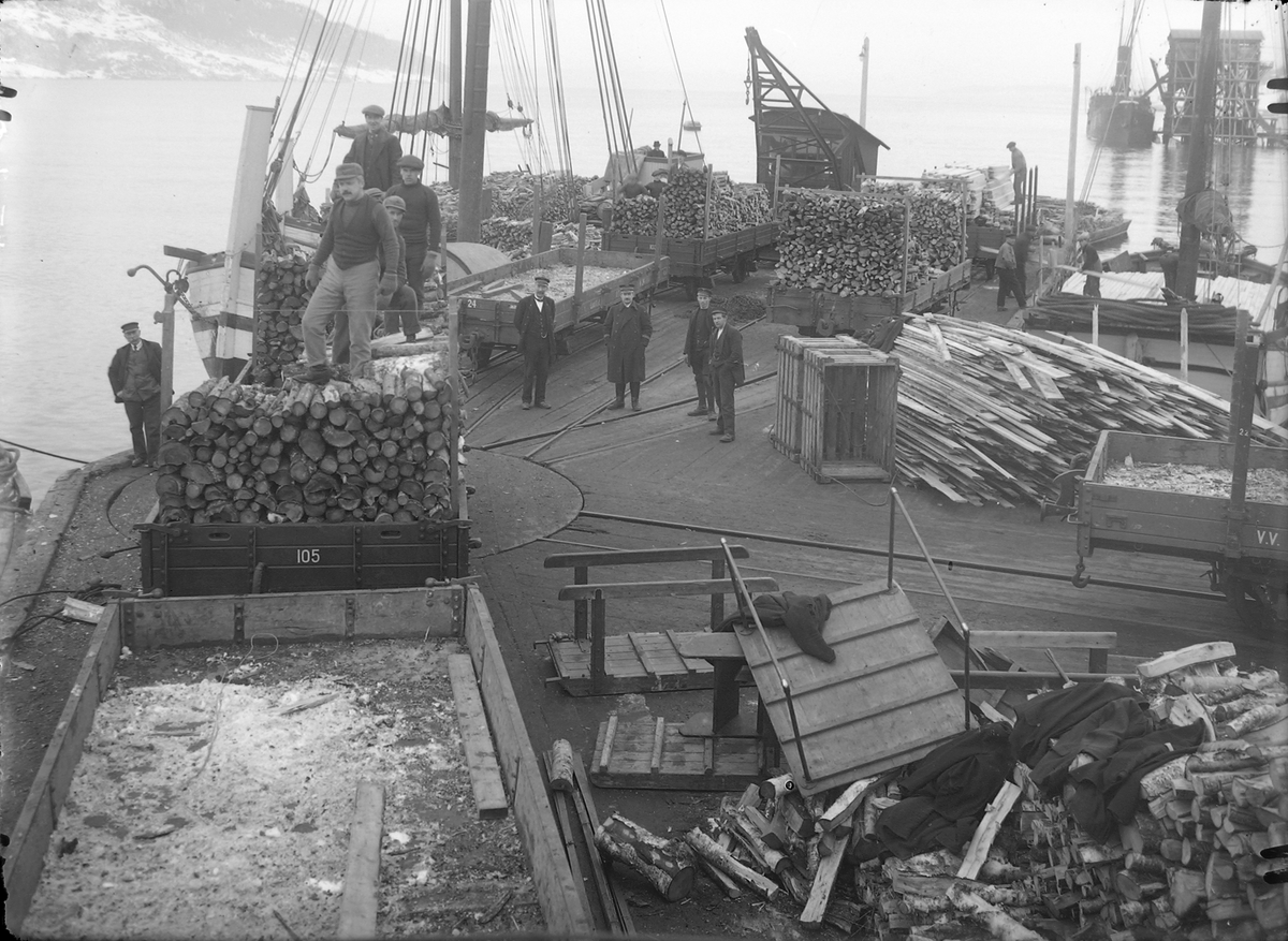 Arbeid med lasting av ved og trelast ombord i båter på Thamshavn.