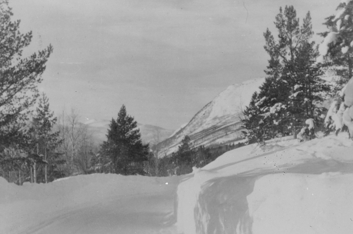 Vinterbilde - brøytet vei med fjell i bakgrunnen