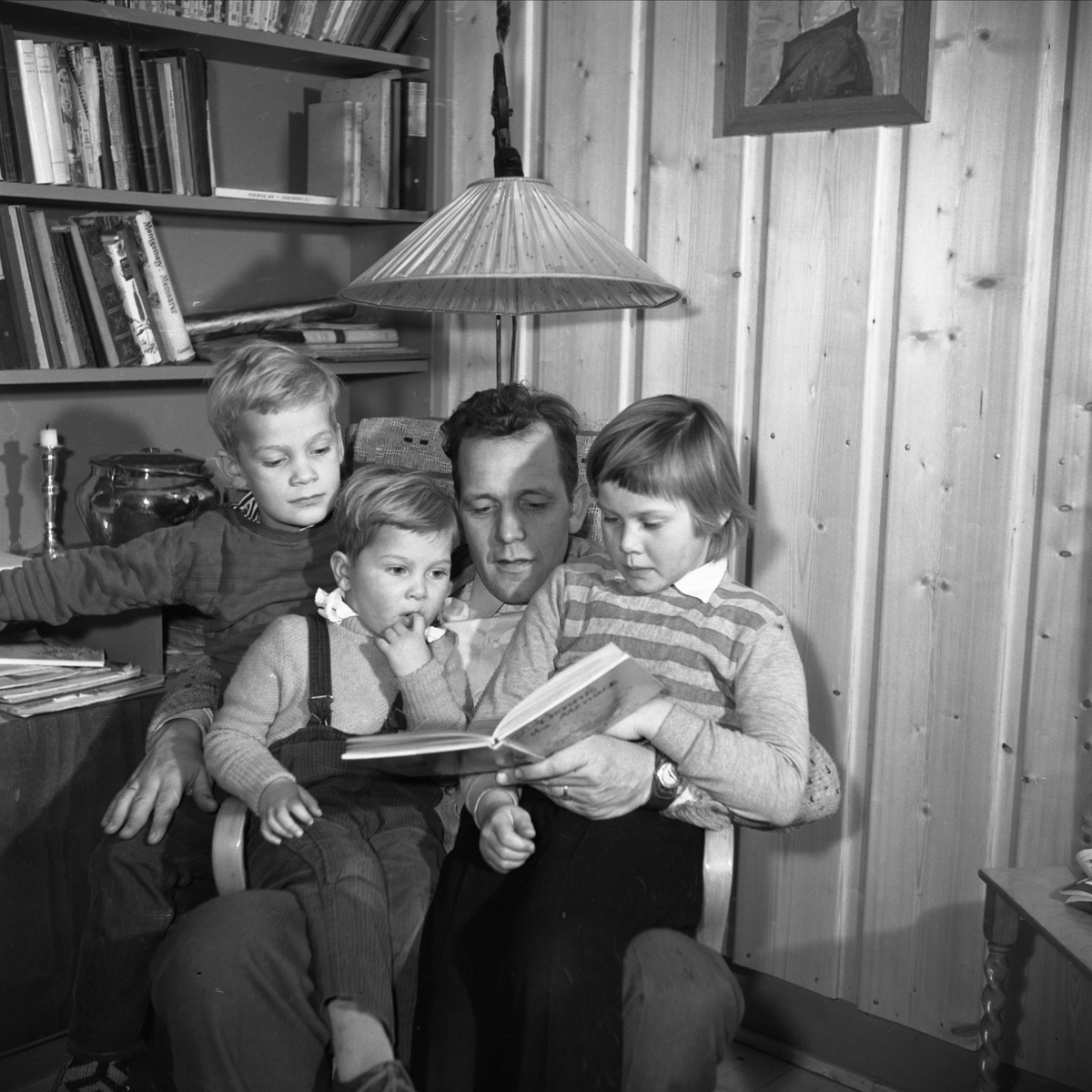 FAMILIEN KJØS, F. V. BJARNE, OLAV, ERIK OG RANDI KJØS, 1959. FAR LESER FOR BARNA. 