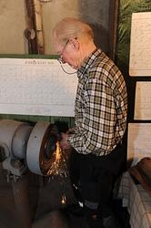 Øksesmeden Oddbjørn Knudsen (f. 1935) fotografert ved slipes