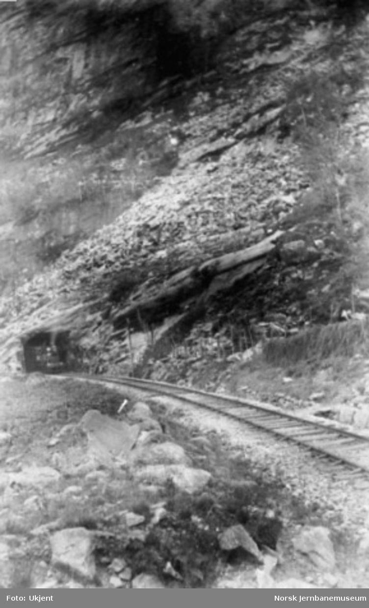 Damplokomotiv kommer ut vestre ende av Kløftefjell tunnel på Vossebanen, trolig under en befaring