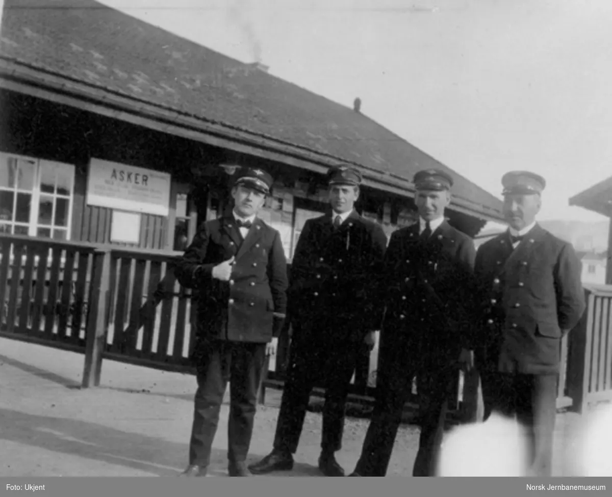 Fire jernbanemenn poserer foran Asker stasjonsbygning