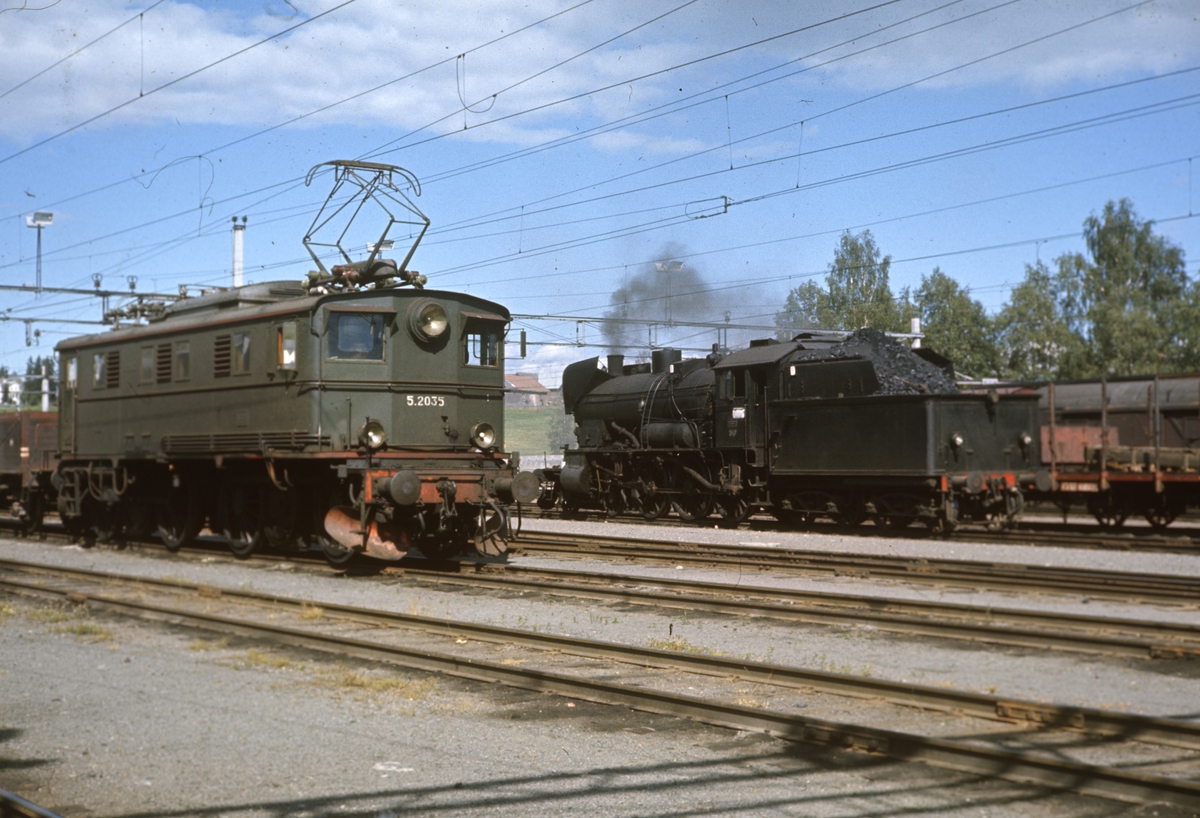 Kryssing mellom godstog på Eina stasjon. Elektrisk lokomotiv El 5 2035 og damplokomotiv tye 30b nr 347.