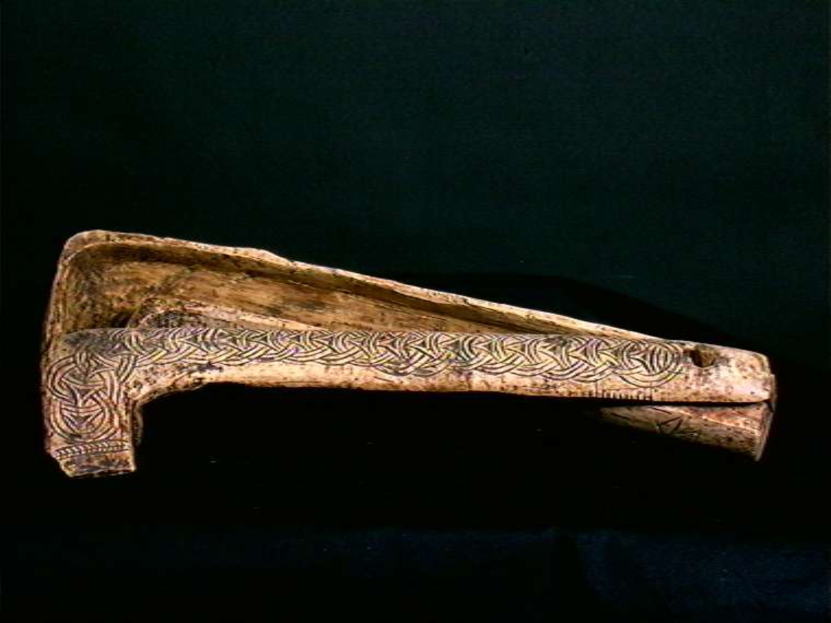 Skrin laget fra et trestykke tatt fra grenfeste. Lokket er skåret tangentielt fra trestykket og bunndelen er siden urholket. Lokket er festet i en dømling ved enden av den lange delen. Skrinet er dekorert med skurd kjedemønster. Dybdedelene i mønstret er forsterket med sot (kolrosingteknikk). Ellers ubehandlet treflater.