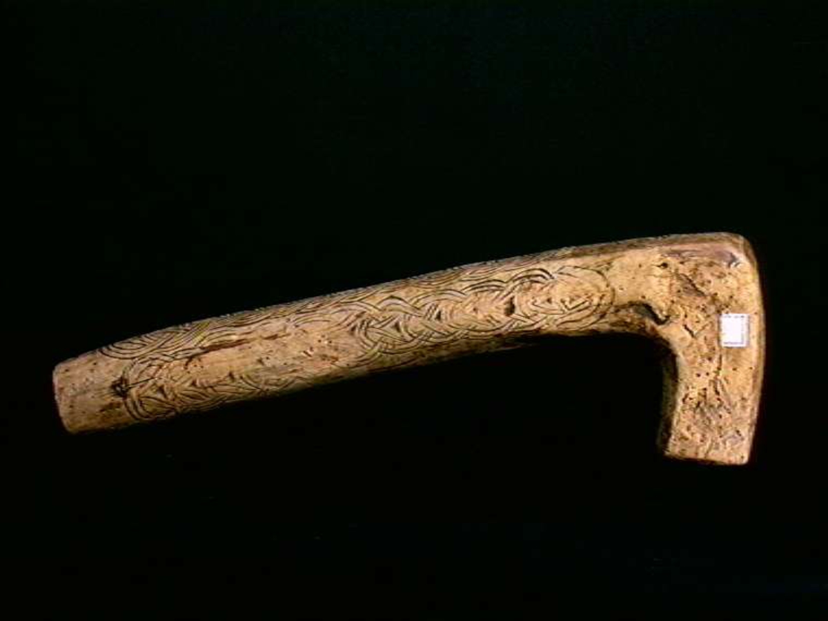 Skrin laget fra et trestykke tatt fra grenfeste. Lokket er skåret tangentielt fra trestykket og bunndelen er siden urholket. Lokket er festet i en dømling ved enden av den lange delen. Skrinet er dekorert med skurd kjedemønster. Dybdedelene i mønstret er forsterket med sot (kolrosingteknikk). Ellers ubehandlet treflater.