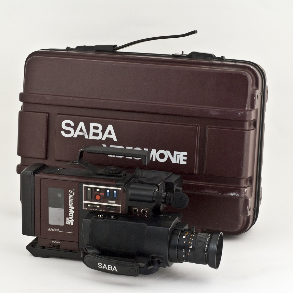 Videokamera med koffert, videokassett, lader og mappe med kvitteringer. 