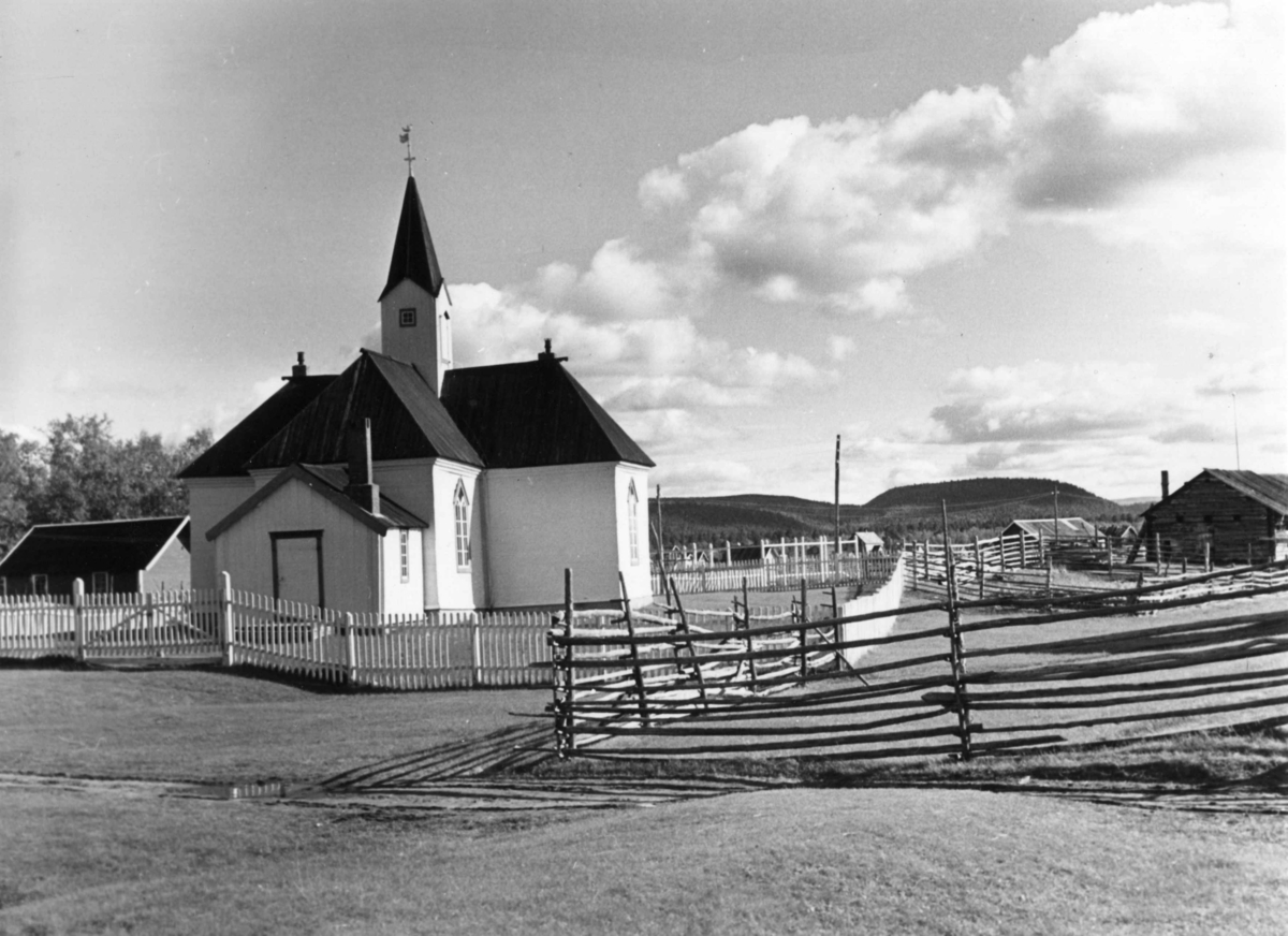 Karasjok kirke med omkringliggende bebyggelse og en vei.