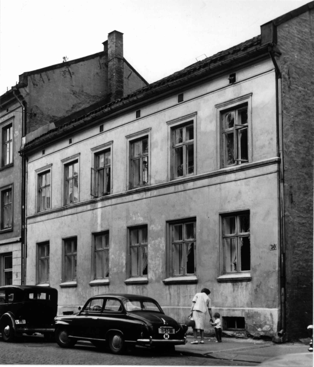 Korsgata 30, Grünerløkka, Oslo 1961. Gatebilde med parkerte biler og kvinne med barn foran huset.