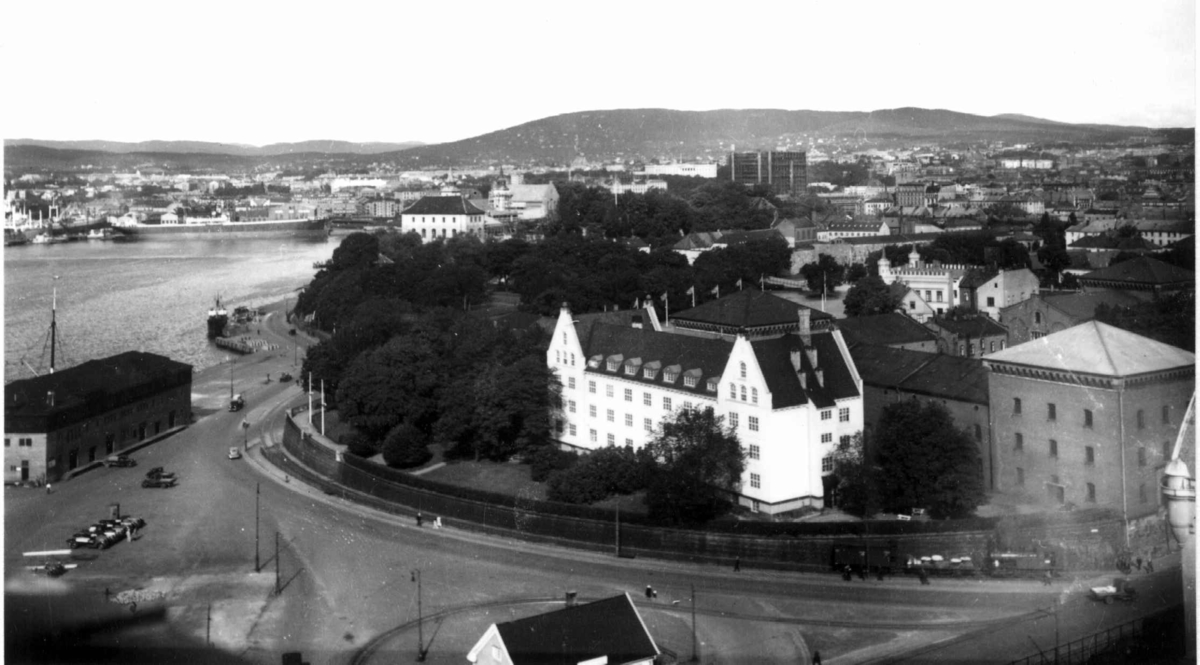 Oslo. Oversiktsbilde. Utsikt over Akershus festning, havna og byen. Skip ved kai. Biler. Slottet i bakgrunnen.