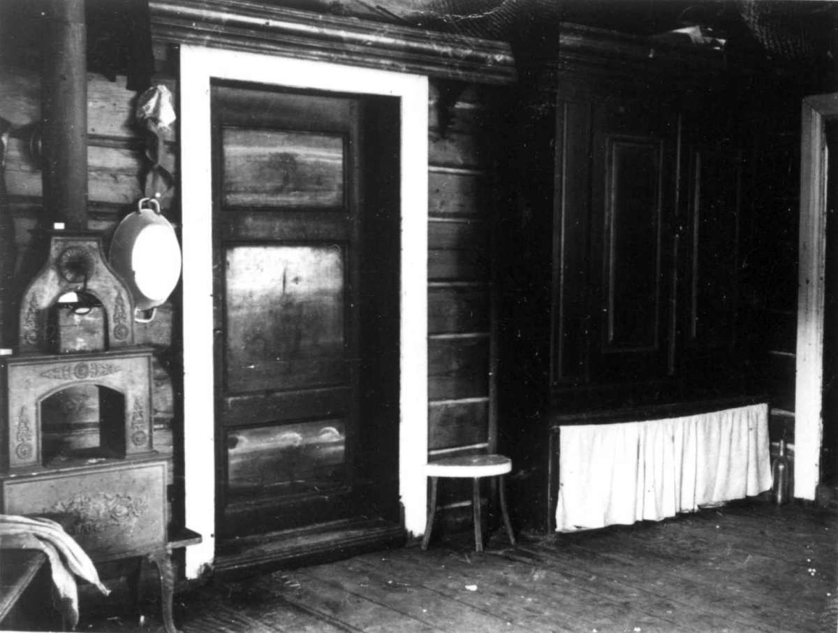 Dalen, Fåset, Tynset, Hedmark 1921. Mønsaasstue. Interiør med ovn og skap.