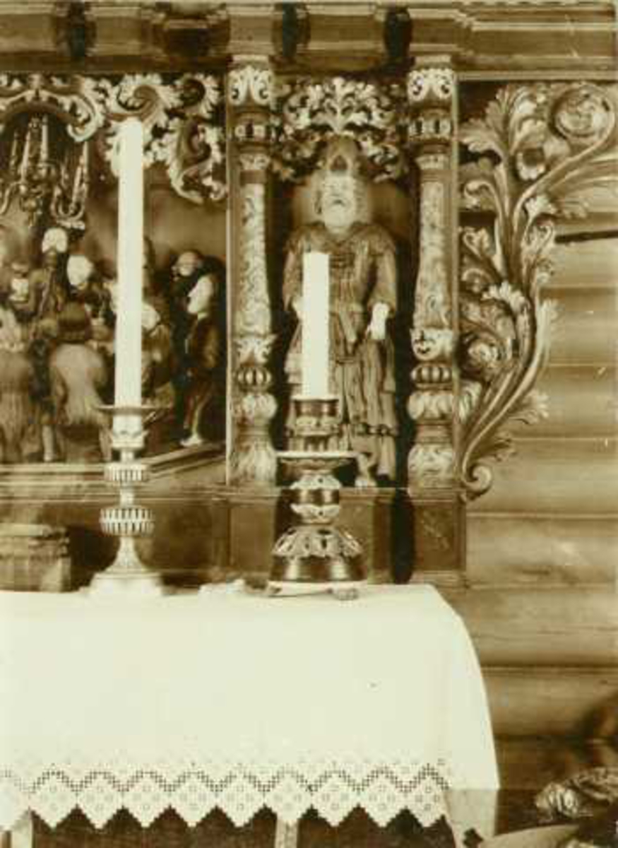 Detalj fra altertavle og alterstaker av tre. Lesja kirke, Lesja, Oppland. Altertavlen skåret  av J.B. Klukstad. Fotografert 1910.