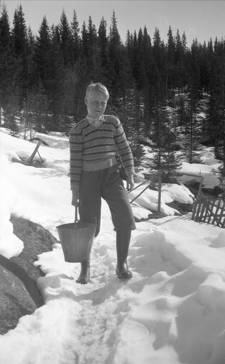 Arne Ramstad henter vann ved Arentz-familiens feriested Ligardshaug. Fotografert påsken 1950.