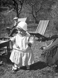 Siri Arentz går i hagen mens bestefaren Eyvind Arentz sitter