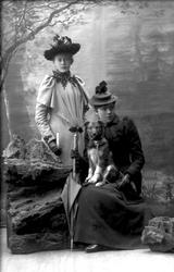 Gruppeportrett, to piker med hund.