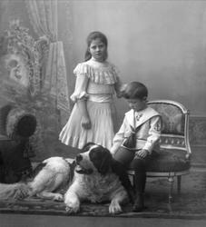 Gruppeportrett, to barn og en stor St. Bernhardshund. Kaptei