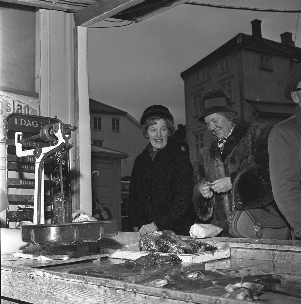 Arendal. Kvinner handler i fiskebod på Fiskebryggen, Tyholmen. Før 1964 salg fra åpne boder.