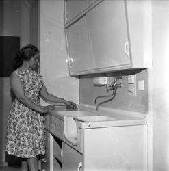 Kvinne ved kjøkkeninnredning. Oslo, Festningen, 18.05.1960, 