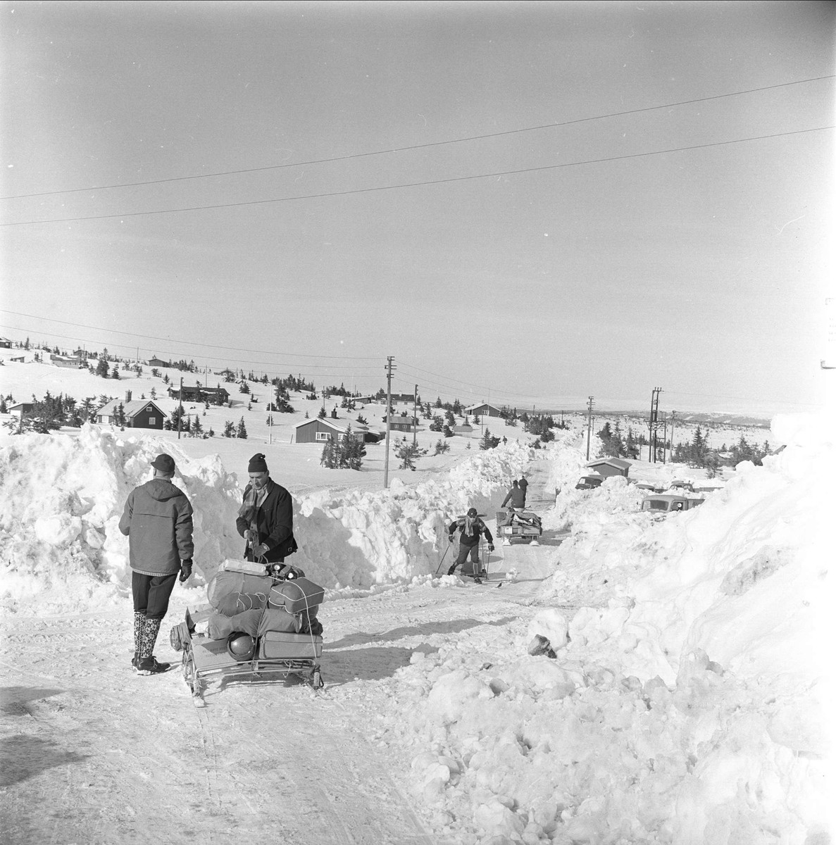 Sjusjøen, Ringsaker, Hedmark, april 1963. Mennesker og hytter på fjellet.