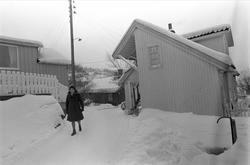 Drøbak, Frogn, 01.03.1970. Kvinne i bygate med snø. Trehusbe