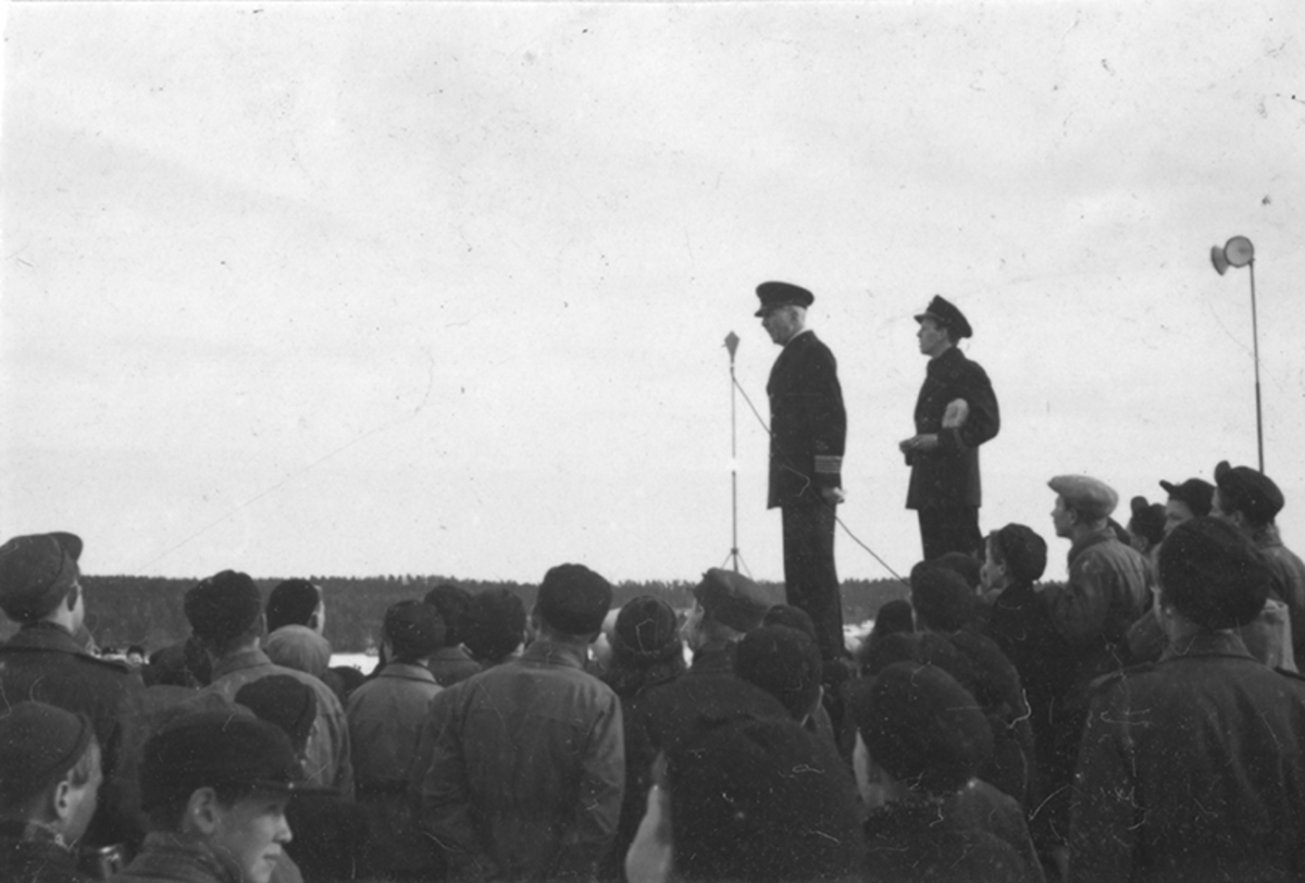Skolbarn på besök på F 2 Roslagens flygflottilj, 1944. Samling utomhus vid hangar. Chefen för F 2, Herman Sundin, talar.