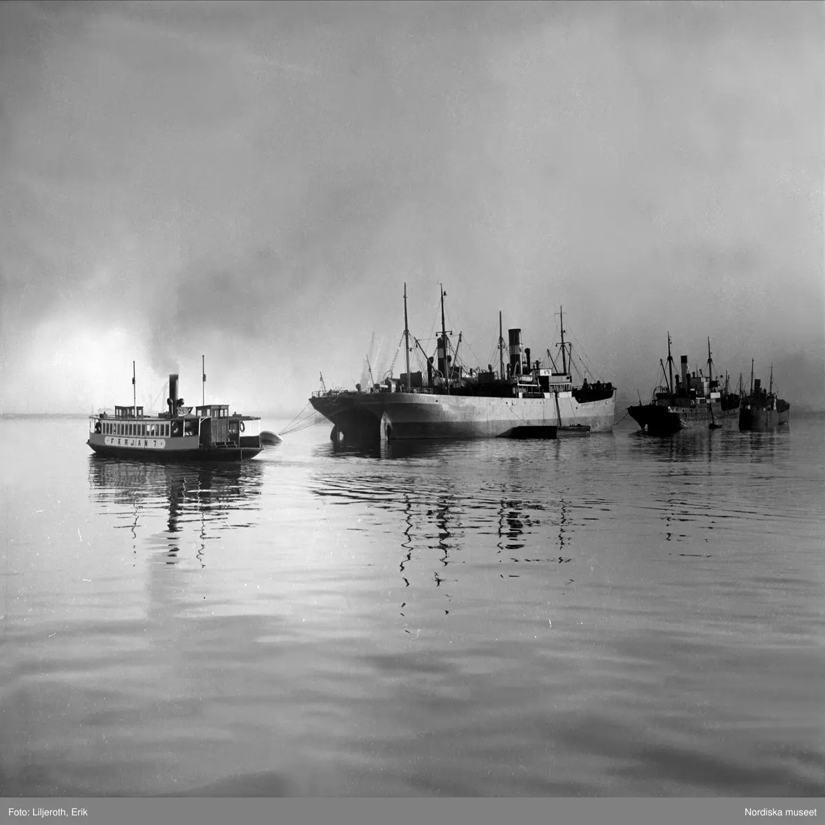 En färja passerar ett fraktfartyg vid Göteborgs hamn.