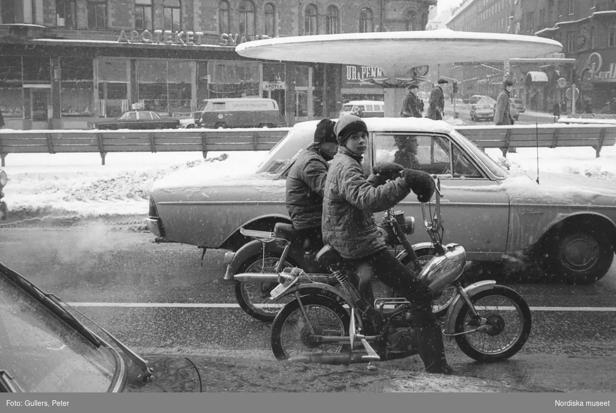 Två pojkar på moped i snöslask vid Stureplan, Stockholm
