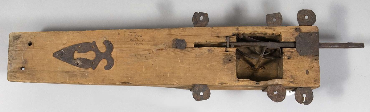Stocklås med nyckel (se UM41802b). Stocklåset är av trä och järn. Det är märkt "EC. 846. Alsike sn Uppl."