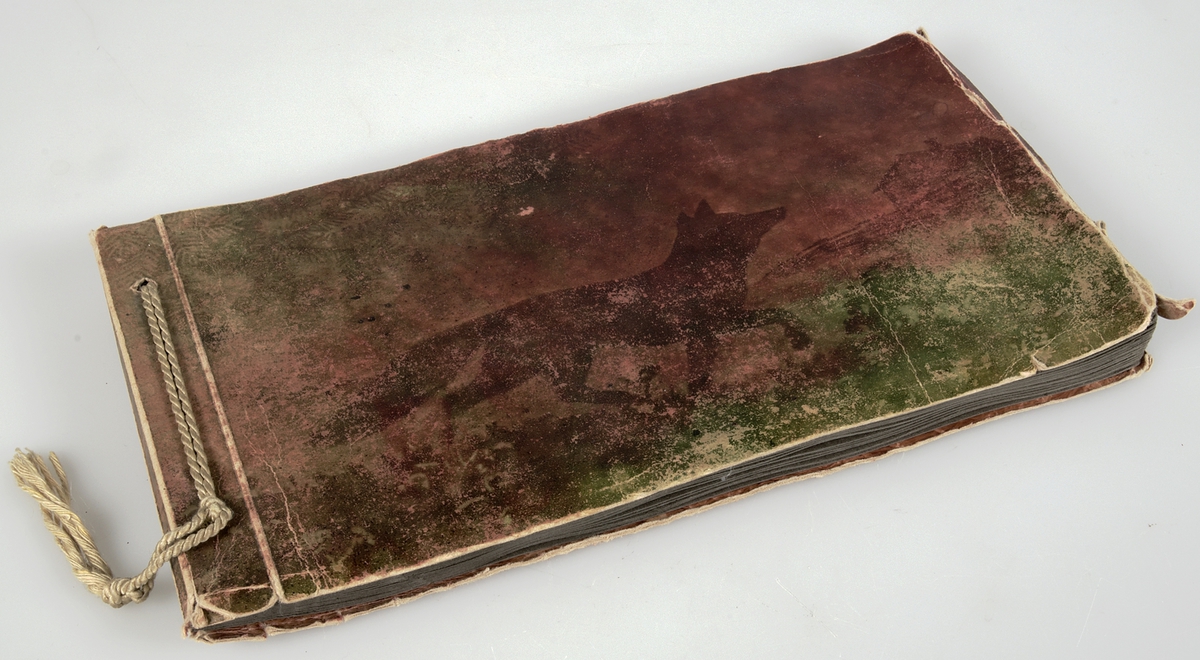 Fotoalbum i papper. På framsidan en rödbrun och grön ton med ett föreställande motiv av en räv, träd och en gård. Fotografierna.....