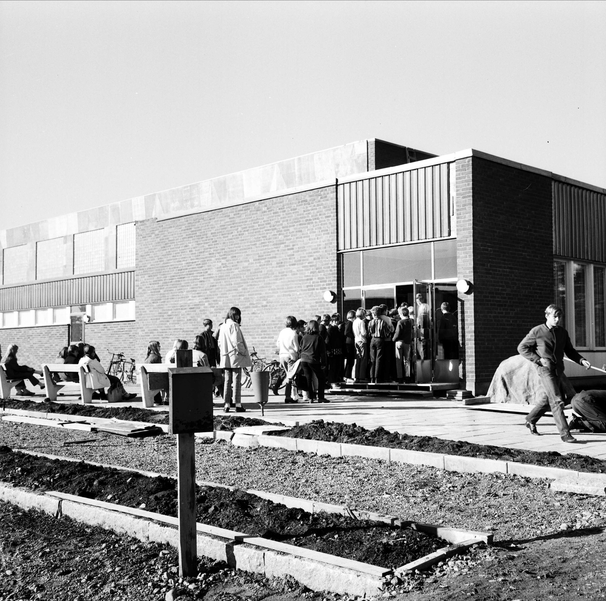 Barn köar för att komma in i skolbyggnad, sannolikt Tierp, Uppland, 1967
