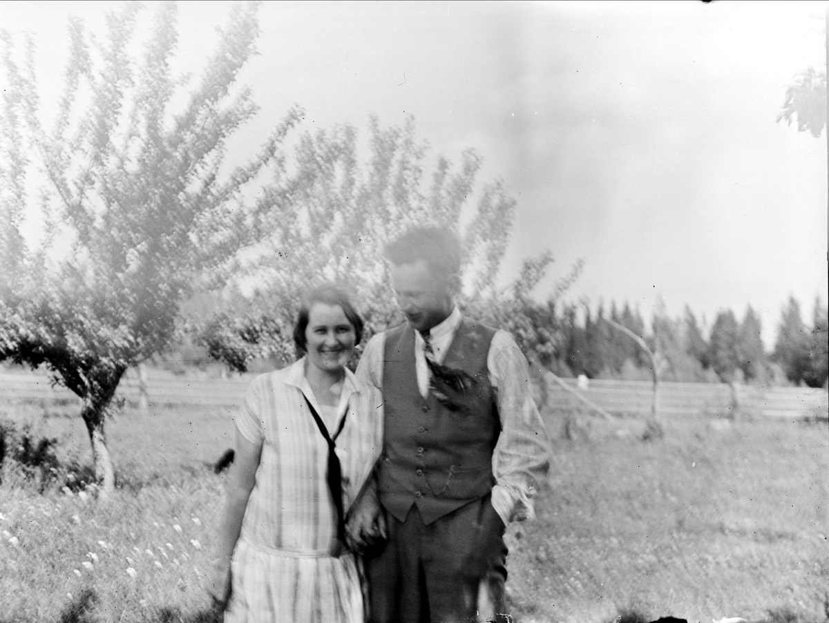 Ung kvinna och man håller varandra i händerna, Tierpstrakten, Uppland omkring 1915 - 1920