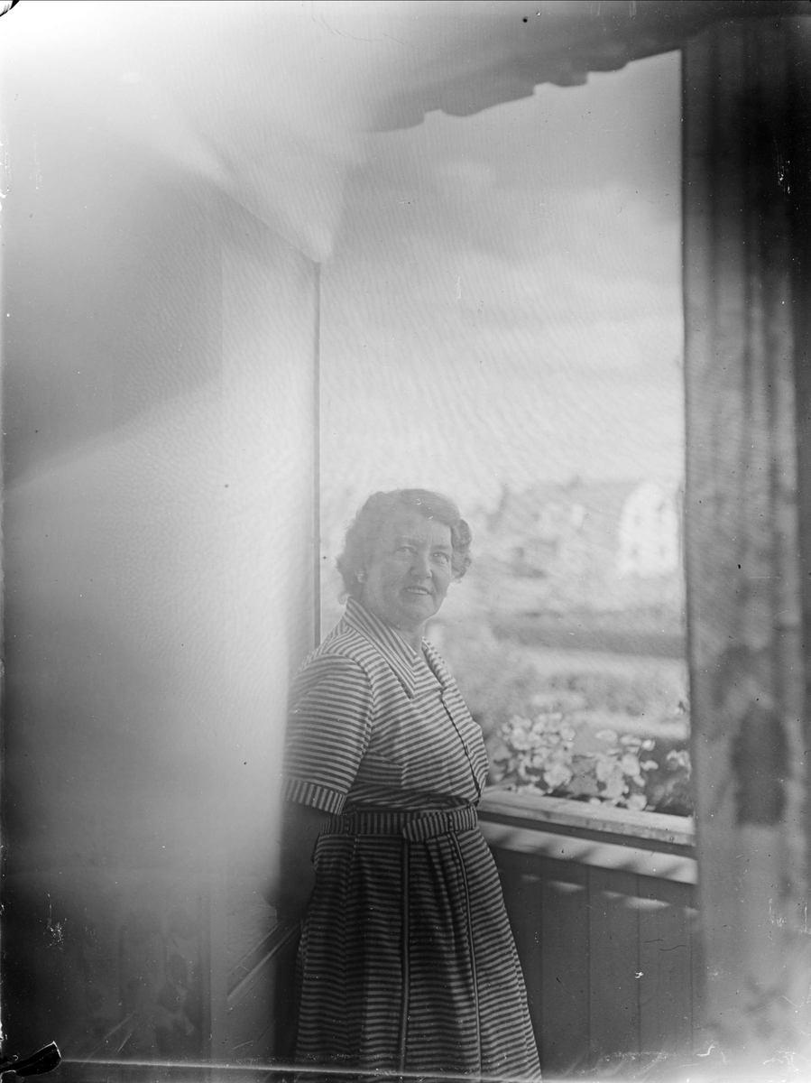 Kvinna vid fönster, Tierpstrakten, Uppland omkring 1915 - 1920