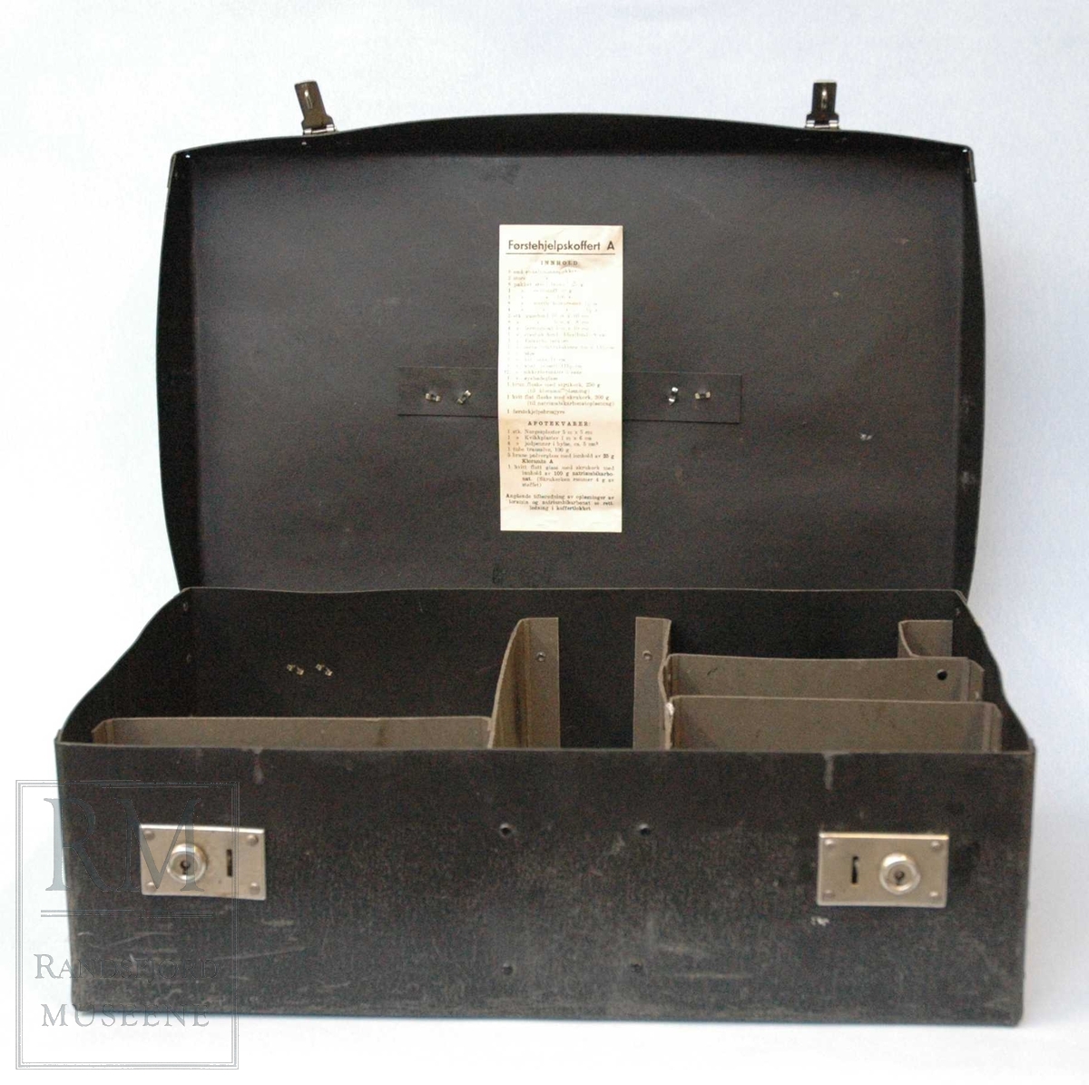 a) koffert i stiv papp. 2 stk lås i blankt metall med nøkkelhull.Kofferten inneholder 8 rom adskilt av pappvegger. 
b) pinsett
c) plaster

