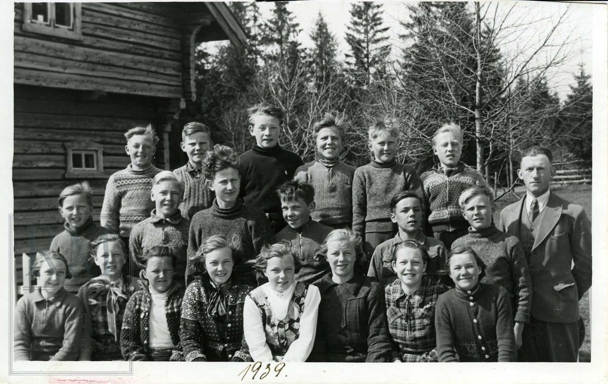 Skolebilde fra Nordre Oppdalen skole. Lærer og elever på trappa utenfor skolebygningen.