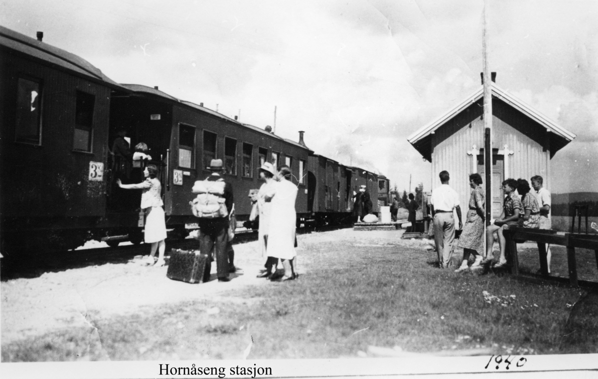 Hornåseng stasjon med tog retning Sørumsand og mange fremmøtte på stasjonen.