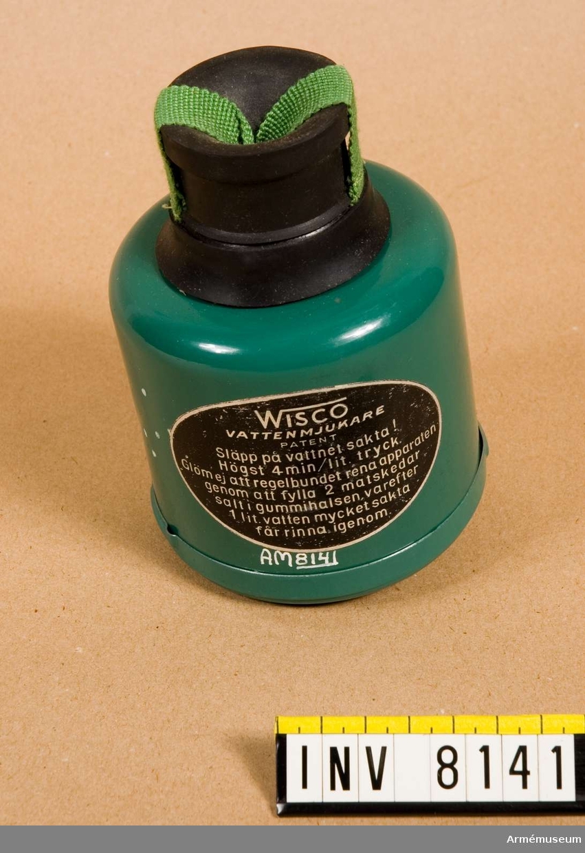 Vattenmjukare Wisco.Tillverkad av grön och svart plåt och gummi. Klistrad etikett  "Wisco vattenmjukare Patent". I botten med vit oljefärg "C". Apparaten skall sättas på en vattenkran. Vattnet får rinna igenom med högst 4 min/liter (sic!) tryck. Rening av apparaten görs med 2 matskedar salt som läggs i gummivalsen varefter en liter vatten sakta får rinna igenom. Bruksanvisning finns i  förpackningen.Ingår i fotomaterielsats 7 låda 2.
