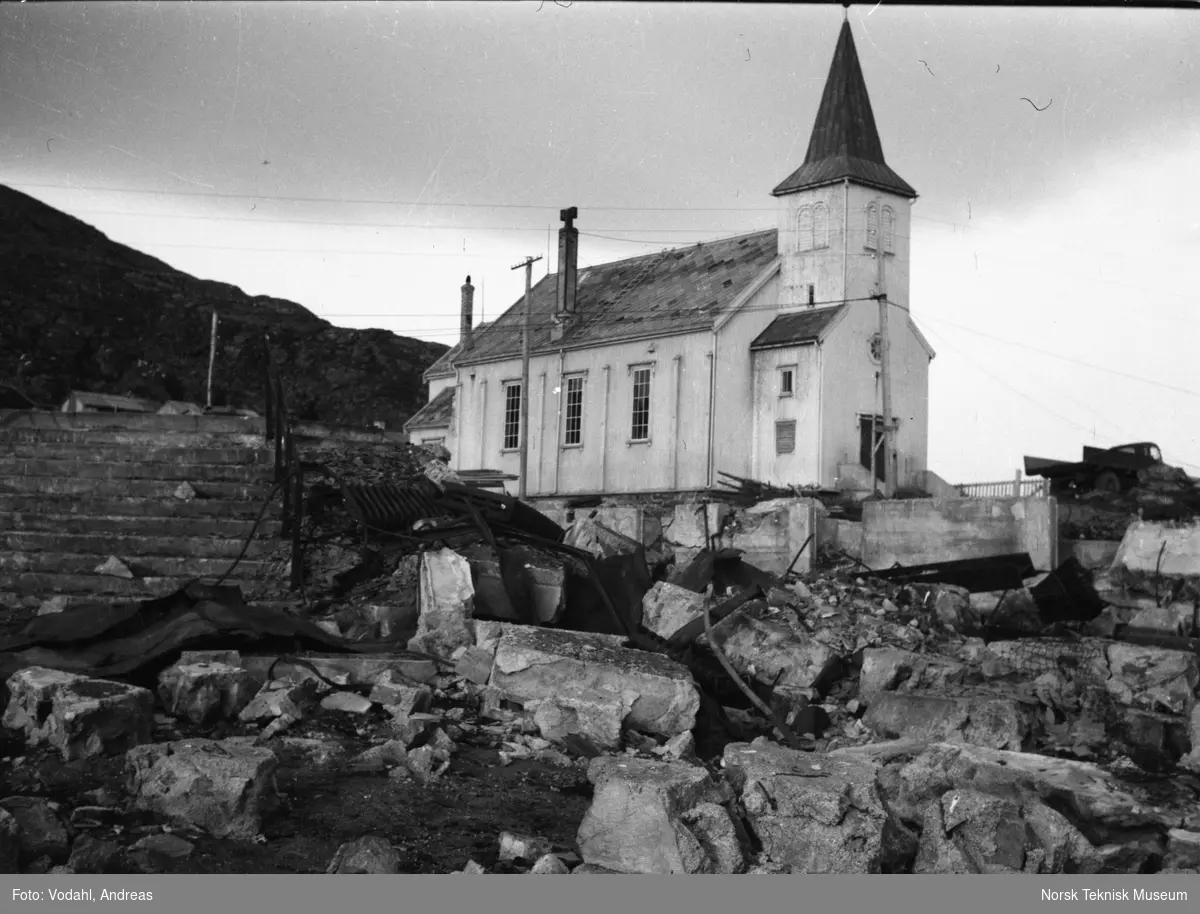Kirken i Honningsvåg med rester av skolebygningen i forgrunnen fotografert sommeren 1945
