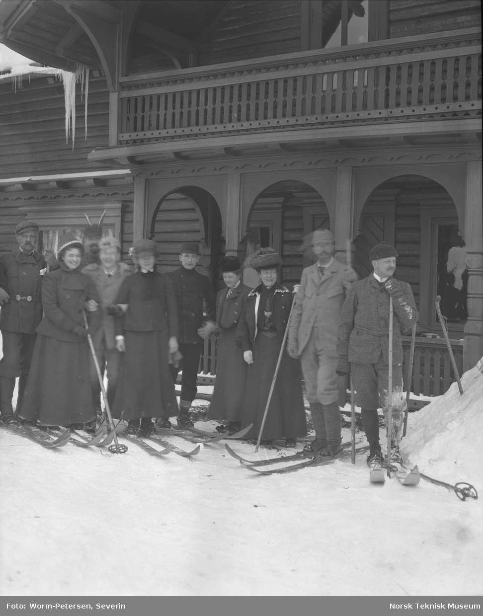 Gruppe på ski utenfor hus