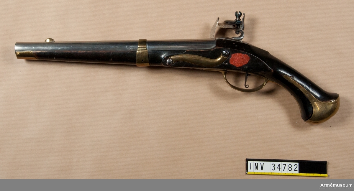 Grupp E III.
1802 års reparationsmodell från 1738 års pistol, med flintlås. Stämpel på låset med bokstäverna P B eller P R. Beslag av mässing. På stockens vänstra sida bakom sidblecket finns Krigskollegiums sigill i rött lack.